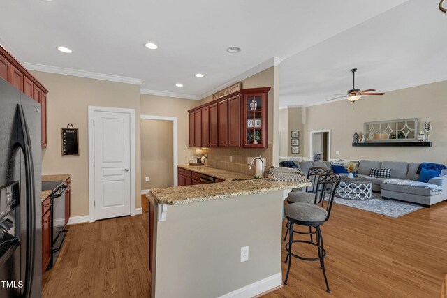 95 Live Oak Dr, Louisburg, NC 27549 - kitchen featuring electric range, a sink, ornamental molding, light wood-type flooring, and a breakfast bar area
