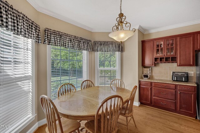 95 Live Oak Dr, Louisburg, NC 27549 - dining room with healthy amount of natural light, light wood-style floors, ornamental molding, and baseboards