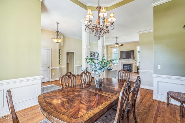 95 Live Oak Dr, Louisburg, NC 27549 - dining area with ceiling fan, crown molding, wood finished floors, a fireplace, and wainscoting