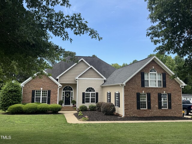 95 Live Oak Dr, Louisburg, NC 27549 - view of front of property with a front lawn, brick siding, and a shingled roof