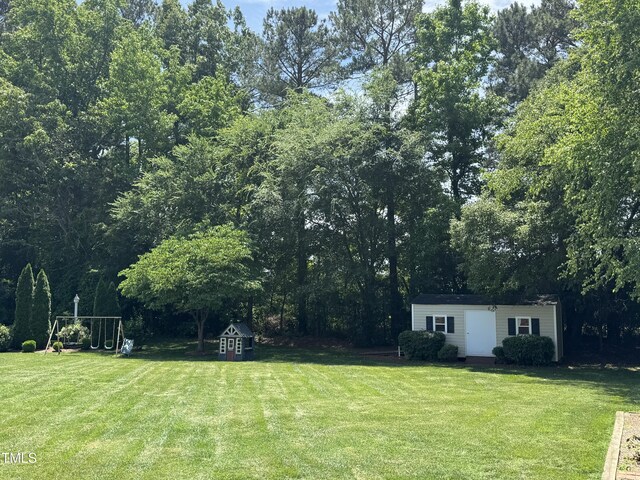 95 Live Oak Dr, Louisburg, NC 27549 - view of green lawn with an outdoor structure and a storage shed