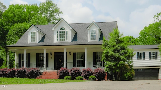 view of front of house featuring an attached garage, a shingled roof, covered porch, and concrete driveway