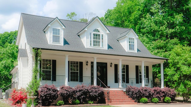 cape cod home with a porch and roof with shingles