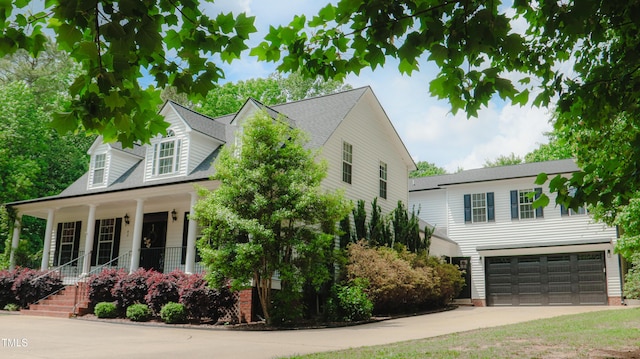 view of front facade with a garage, covered porch, and concrete driveway