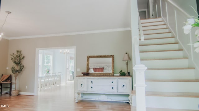 stairway with crown molding, baseboards, wood finished floors, and a chandelier