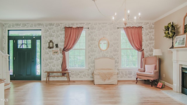 living area with a fireplace with flush hearth, an inviting chandelier, wallpapered walls, and wood finished floors