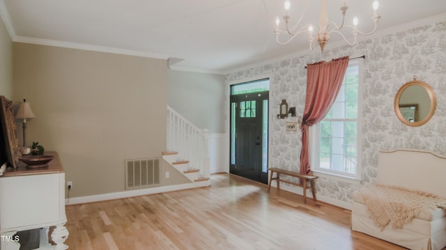 entrance foyer with stairway, a wealth of natural light, a chandelier, and visible vents