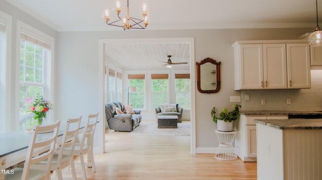 interior space featuring light wood-style floors, baseboards, crown molding, and an inviting chandelier