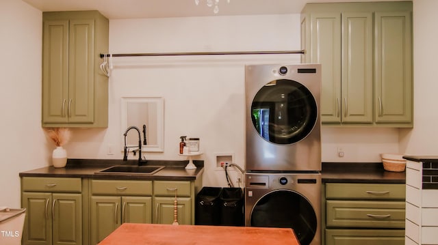 clothes washing area with a sink, stacked washer and clothes dryer, and cabinet space