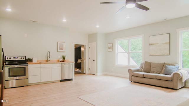 living room with a ceiling fan, recessed lighting, light wood-style flooring, and a wealth of natural light