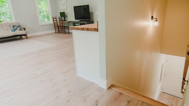 interior space featuring baseboards and light wood finished floors