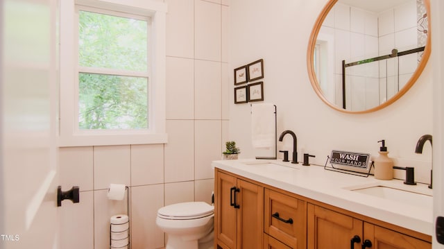 full bathroom with double vanity, toilet, plenty of natural light, and a sink
