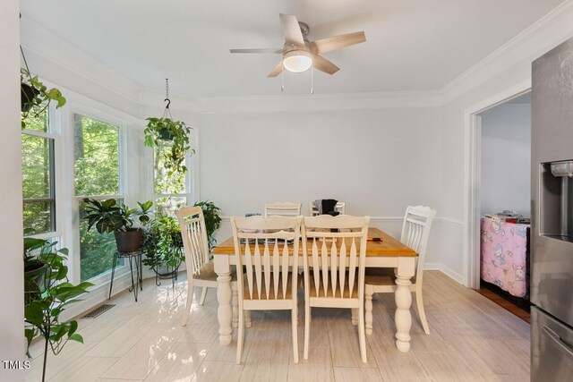 dining space featuring crown molding, ceiling fan, and visible vents