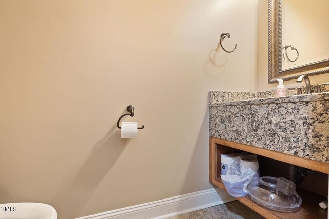 bathroom featuring baseboards, a sink, and toilet