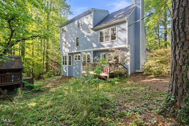 back of property with a deck and a chimney