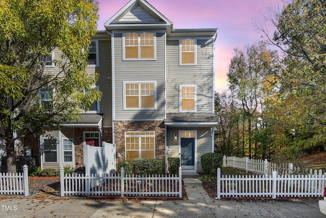 view of property featuring a fenced front yard and stone siding