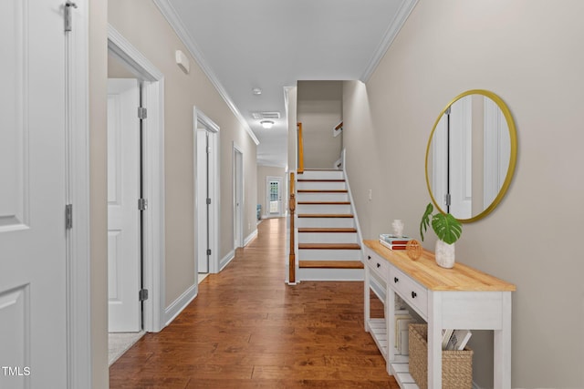 hallway with crown molding, baseboards, stairs, and wood finished floors
