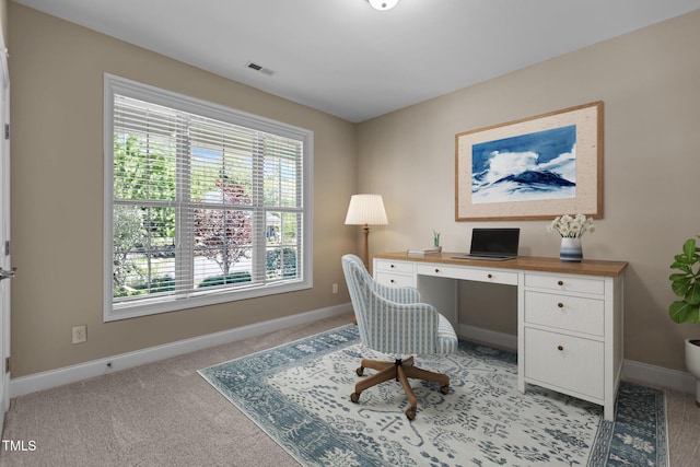 office with baseboards, visible vents, and light carpet