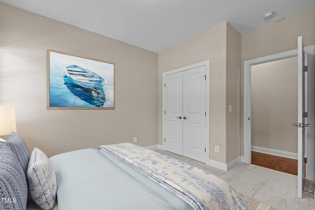 bedroom with a closet, baseboards, and carpet flooring