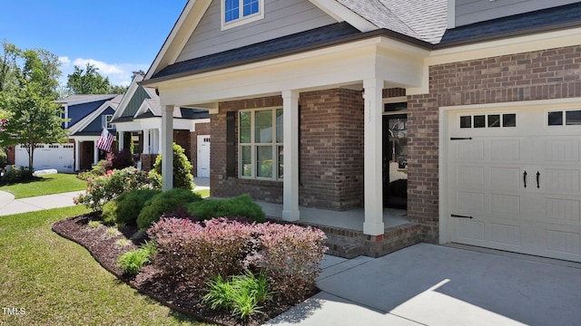 property entrance featuring covered porch, brick siding, and roof with shingles
