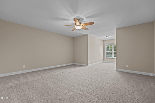 carpeted empty room featuring baseboards and a ceiling fan