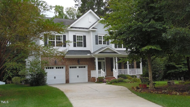 craftsman house with a front lawn, an attached garage, brick siding, a porch, and driveway