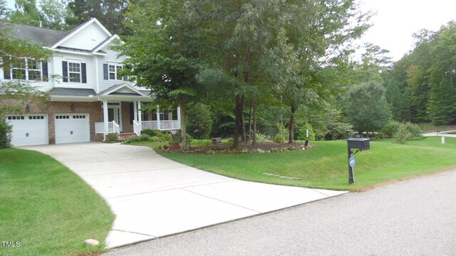106 N Duelling Oaks Dr, Chapel Hill, NC 27517 - view of front of property with a porch, concrete driveway, an attached garage, a front yard, and brick siding