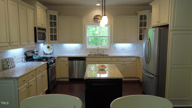 106 N Duelling Oaks Dr, Chapel Hill, NC 27517 - kitchen with stainless steel appliances, a sink, backsplash, decorative light fixtures, and light stone counters