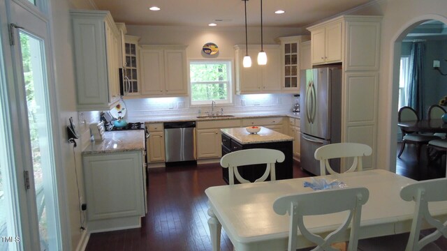 106 N Duelling Oaks Dr, Chapel Hill, NC 27517 - kitchen with appliances with stainless steel finishes, a sink, a center island, arched walkways, and tasteful backsplash