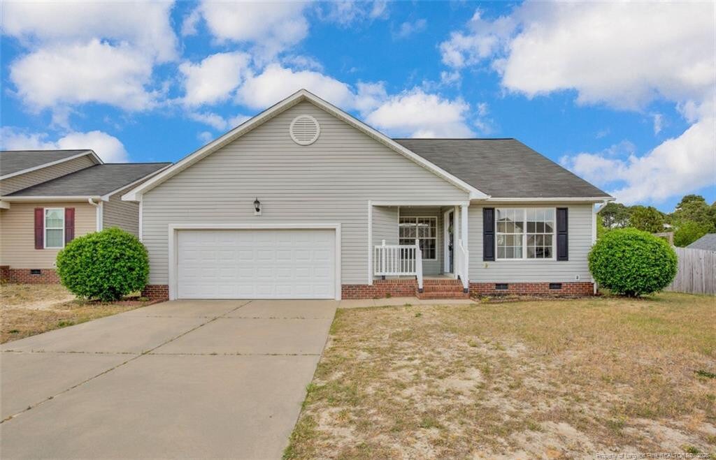 ranch-style home featuring crawl space, driveway, roof with shingles, a front lawn, and an attached garage