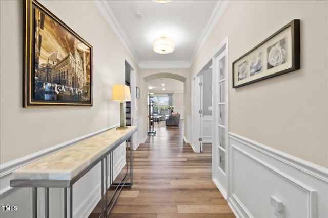 1533 Santa Lucia St, Wake Forest, NC 27587 - hallway featuring crown molding, arched walkways, wood finished floors, a wainscoted wall, and a decorative wall