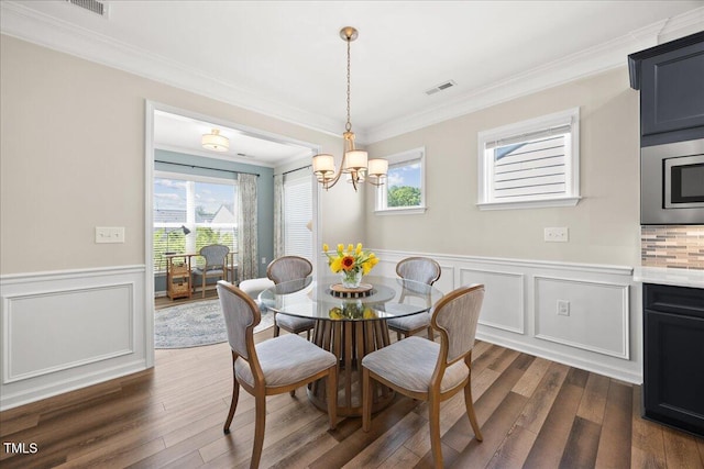 1533 Santa Lucia St, Wake Forest, NC 27587 - dining space with crown molding, a chandelier, dark wood-style flooring, a wainscoted wall, and healthy amount of natural light