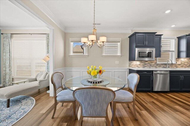 1533 Santa Lucia St, Wake Forest, NC 27587 - dining room with a chandelier, wood finished floors, crown molding, and a wainscoted wall