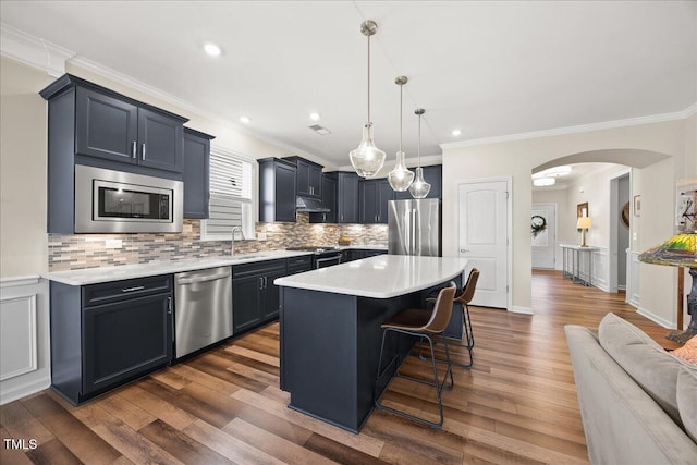 1533 Santa Lucia St, Wake Forest, NC 27587 - kitchen with stainless steel appliances, a breakfast bar, arched walkways, light countertops, and a sink