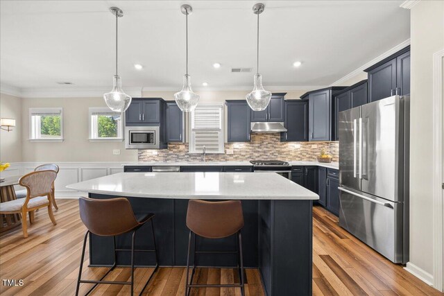 1533 Santa Lucia St, Wake Forest, NC 27587 - kitchen with stainless steel appliances, under cabinet range hood, a kitchen island, a sink, and a breakfast bar area