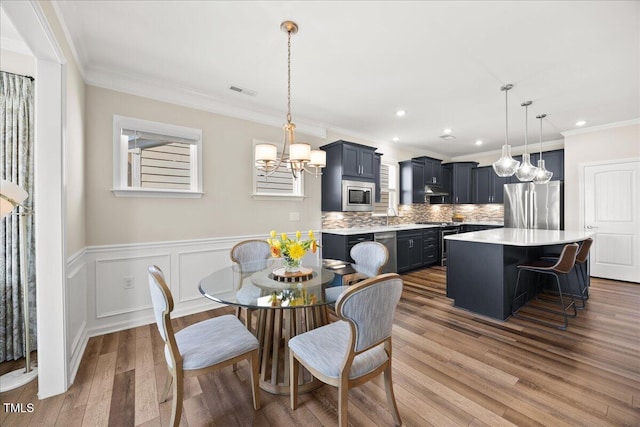 1533 Santa Lucia St, Wake Forest, NC 27587 - dining area featuring wood finished floors, a chandelier, ornamental molding, recessed lighting, and a wainscoted wall