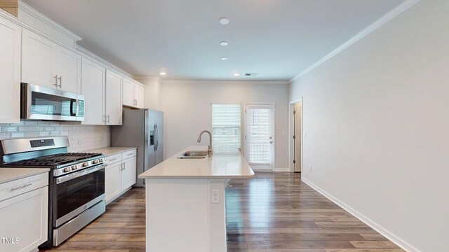 1314 Rosepine Dr, Cary, NC 27519 - kitchen featuring appliances with stainless steel finishes, a sink, tasteful backsplash, crown molding, and white cabinets