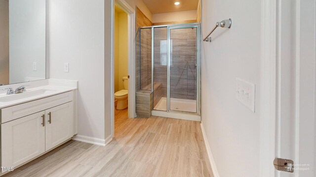 1314 Rosepine Dr, Cary, NC 27519 - bathroom featuring a shower stall, vanity, baseboards, and wood finished floors