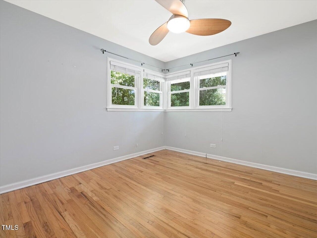 empty room featuring a ceiling fan, baseboards, and light wood-style flooring