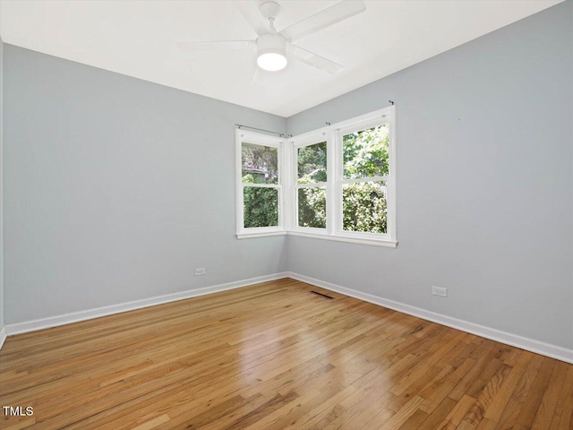 spare room with baseboards, visible vents, light wood-style flooring, and ceiling fan