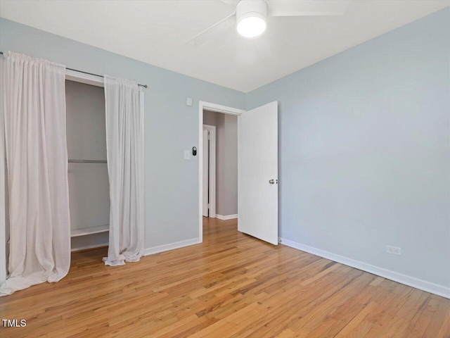unfurnished bedroom with a closet, light wood-style floors, baseboards, and a ceiling fan