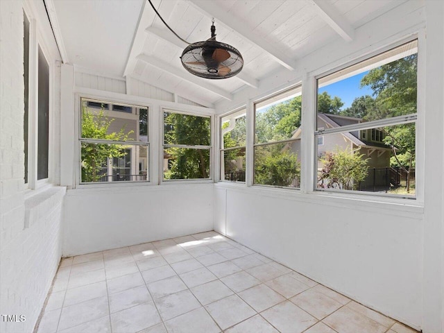 unfurnished sunroom featuring tile patterned floors and vaulted ceiling with beams