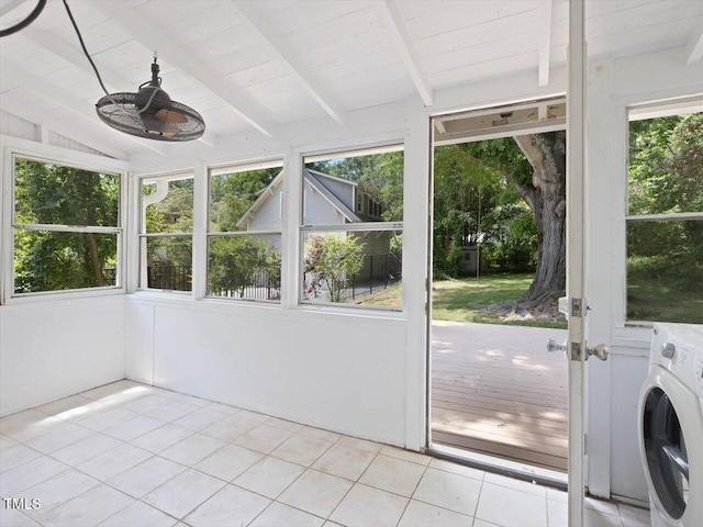 unfurnished sunroom featuring a wealth of natural light, tile patterned flooring, washer / clothes dryer, and vaulted ceiling with beams