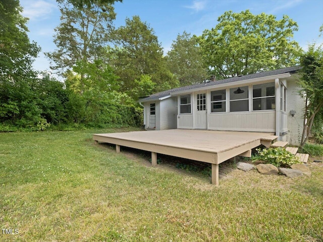 rear view of property with a yard and a wooden deck