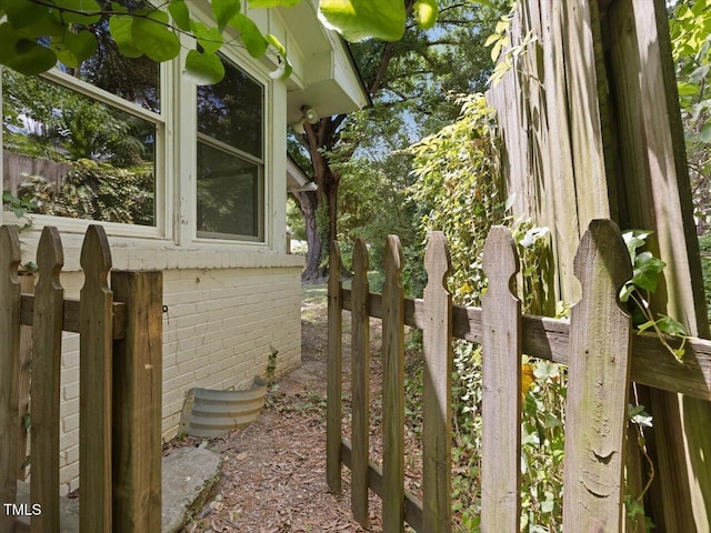 view of home's exterior featuring fence and brick siding