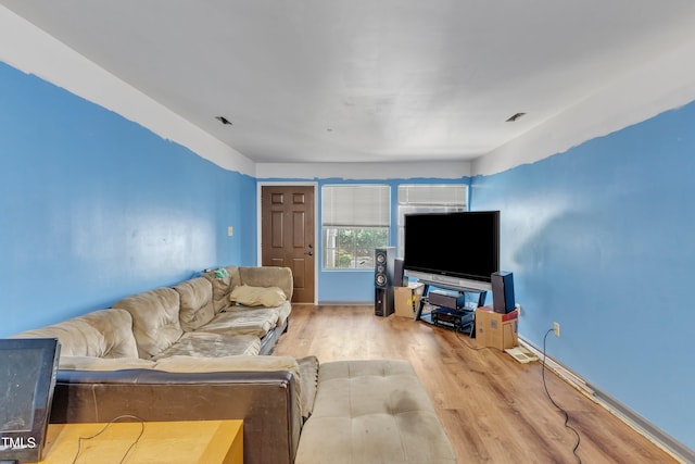 living room featuring baseboards, visible vents, and wood finished floors