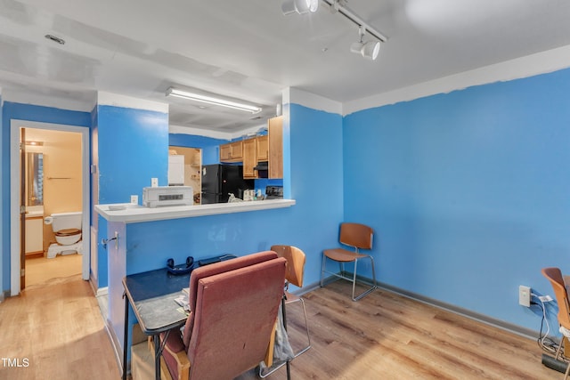 dining area featuring baseboards and light wood-type flooring