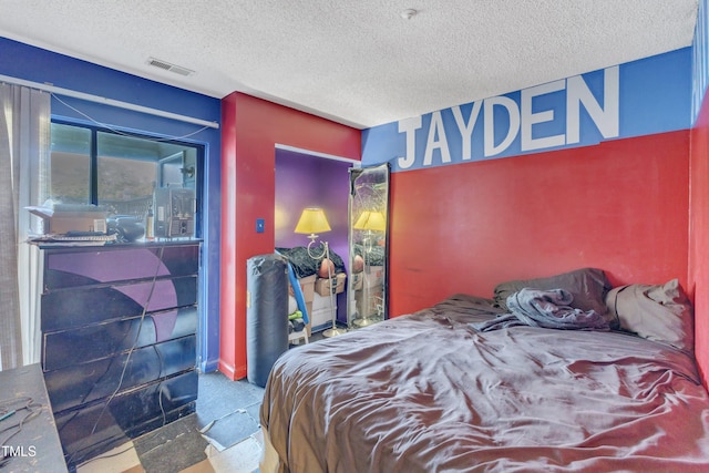 bedroom featuring a textured ceiling and visible vents