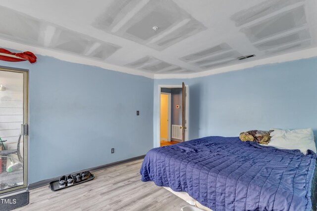 bedroom featuring baseboards, visible vents, and wood finished floors