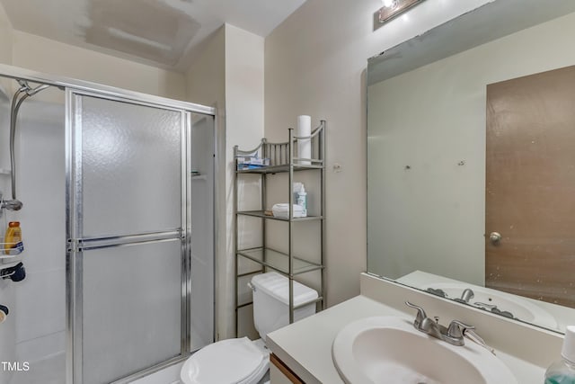 full bath with a shower stall, vanity, and toilet